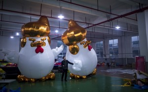 This picture taken on January 6, 2017 shows workers inflating giant chickens resembling Donald Trump in a factory in Jiaxing.  A Chinese factory is hatching giant inflatable chickens resembling Donald Trump to usher in the Year of the Rooster. The five-metre (16-foot) fowls sport the distinctive golden mane of the US president-elect and mimic his signature hand gestures with their tiny wings.  / AFP PHOTO / Johannes EISELE