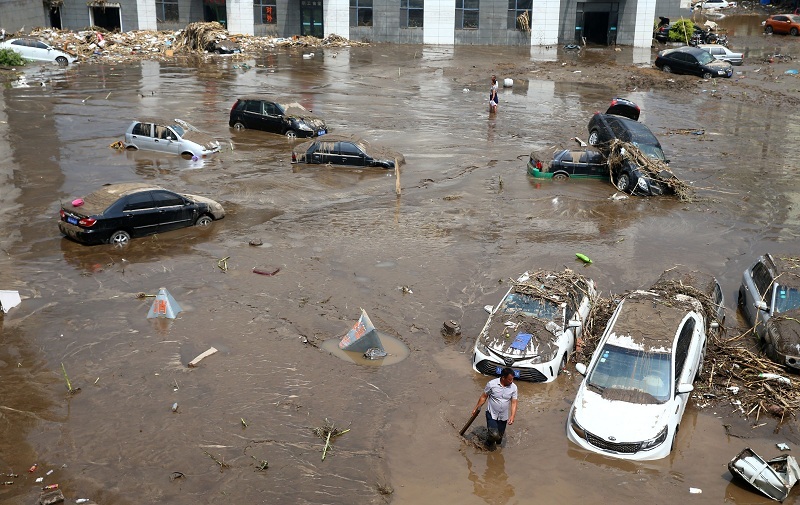 This photo taken on July 14, 2017 shows submerged cars in a flooded street in Yongji, a county under the administration of the city of Jilin in northeast China's Jilin province. Heavy rains caused flooding that left 18 people dead and another 18 missing around Jilin, with more than 110,000 evacuated when flooding hit the city on July 13 and 14. / AFP PHOTO / STR / China OUT