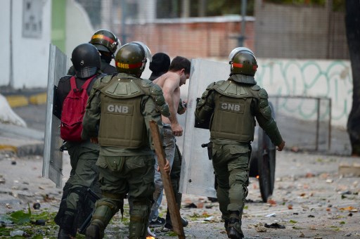 National Guard personnel in riot gear arrest an opposition demonstrator during clashes ensuing an anti-government protest in Caracas, on July 26, 2017. Venezuelans blocked off deserted streets Wednesday as a 48-hour opposition-led general strike aimed at thwarting embattled President Nicolas Maduro's controversial plans to rewrite the country's constitution got underway. / AFP PHOTO / Federico Parra