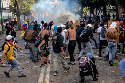 Opposition demonstrators skirmish with riot police ensuing an anti-government protest in Caracas, on July 26, 2017. Venezuelans blocked off deserted streets Wednesday as a 48-hour opposition-led general strike aimed at thwarting embattled President Nicolas Maduro's controversial plans to rewrite the country's constitution got underway. / AFP PHOTO / FEDERICO PARRA