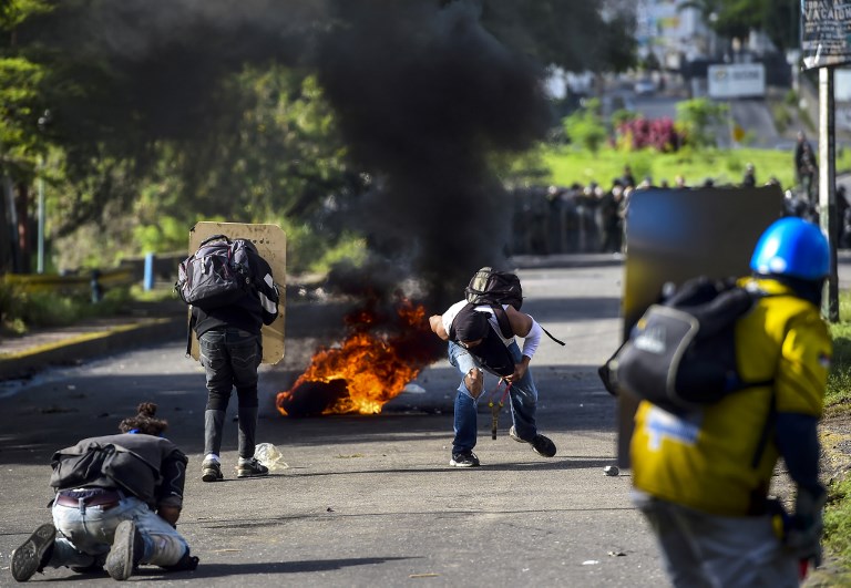 Anti-government activists skirmish with riot police during a protest against the election of a Constituent Assembly proposed by Venezuelan President Nicolas Maduro, in Caracas on July 30, 2017. Deadly violence erupted around the controversial vote, with a candidate to the all-powerful body being elected shot dead and troops firing weapons to clear protesters in Caracas and elsewhere. / AFP PHOTO / RONALDO SCHEMIDT