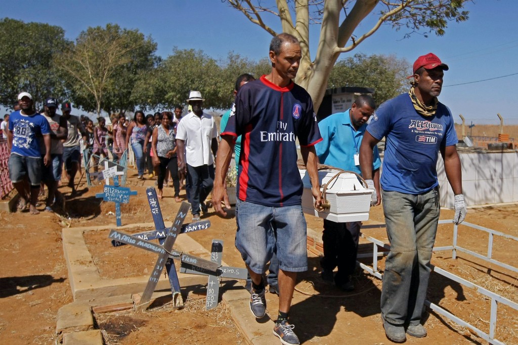 CORRECTION - The coffin of Ana Clara, 4, one of the victims of the municipal daycare centre attack -where a watchman sprayed children with alcohol and set them on fire- is carried during his burial at Saint Luke's cemetery in Janauba, Minas Gerais state, Brazil on October 6, 2017. A Brazilian nursery school guard burned six small children and a teacher to death after spraying them with alcohol and setting them alight Thursday in an attack which has horrified the nation.  / AFP PHOTO / O TEMPO / ALEX DE JESUS / Brazil OUT / The erroneous mention[s] appearing in the metadata of this photo by ALEX DE JESUS has been modified in AFP systems in the following manner: [Ana Clara] instead of [Juan Miguel Soares Silva]. Please immediately remove the erroneous mention[s] from all your online services and delete it (them) from your servers. If you have been authorized by AFP to distribute it (them) to third parties, please ensure that the same actions are carried out by them. Failure to promptly comply with these instructions will entail liability on your part for any continued or post notification usage. Therefore we thank you very much for all your attention and prompt action. We are sorry for the inconvenience this notification may cause and remain at your disposal for any further information you may require.