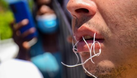 Migrantes se cosen los labios